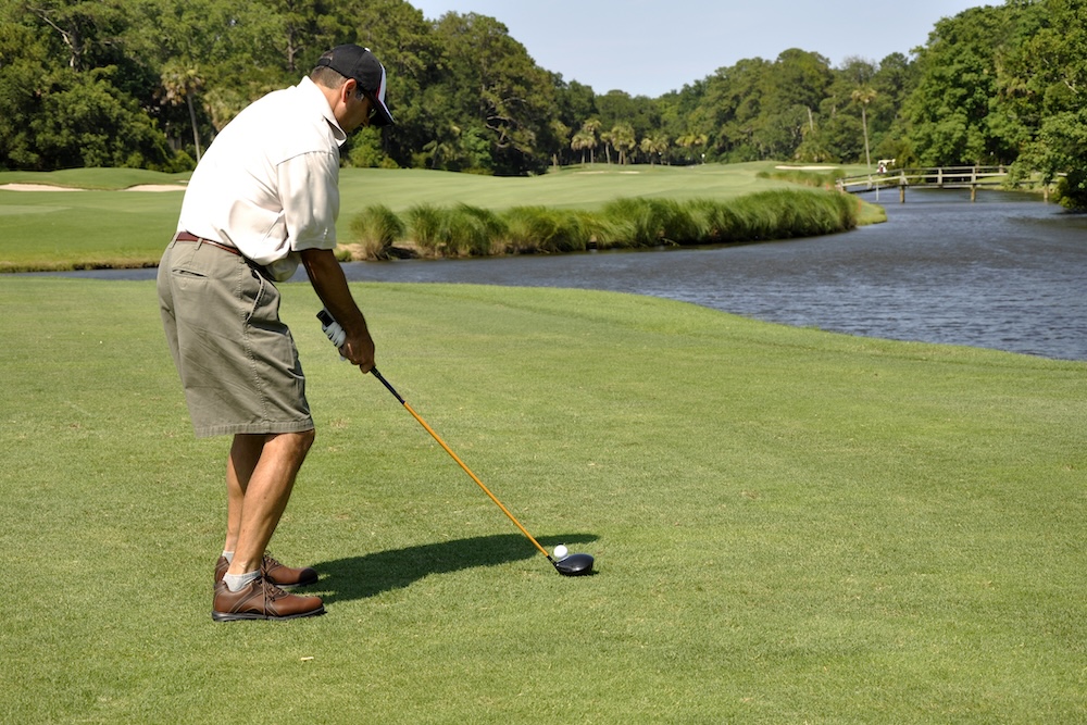 Man golfing on a beautiful golf course at Sea Pines Resort on Hilton Head Island in South Carolina.