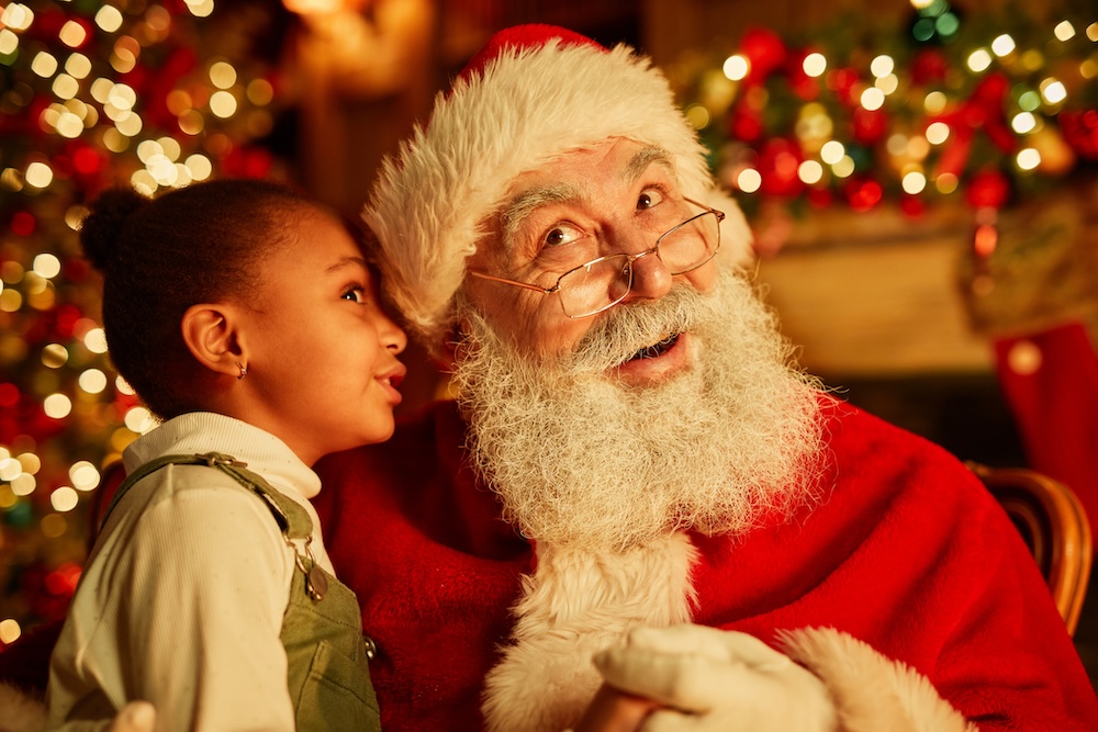 Child telling Santa what she wants for Christmas