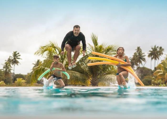family jumping into pool at vacation rental